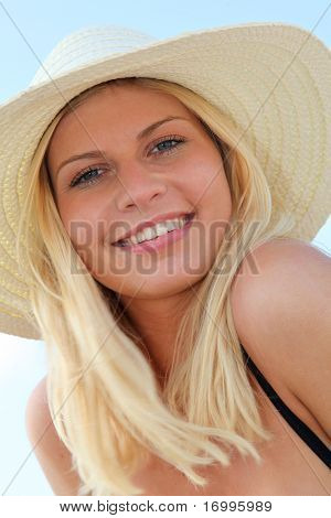 Closeup ของผู้หญิงผมสีทองสวยงามสวมใส่หมวกที่ชายหาด