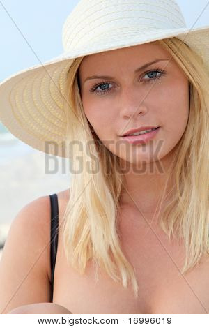 Closeup ของผู้หญิงผมสีทองสวยงามสวมใส่หมวกที่ชายหาด