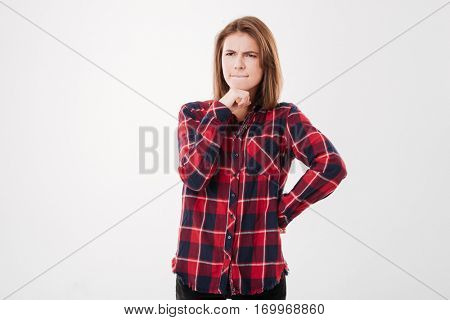 Portrait of a pensive thougtful pretty brunette girl in plaid shirt thinking about something isolated on a white background