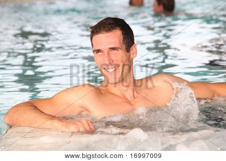 Mand badning i jacuzzien i spa-centret