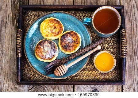 Pancakes with honey on vintage bowl on wooden tray. Studio Photo