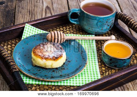Pancakes with honey on vintage bowl on wooden tray. Studio Photo