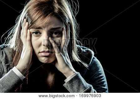 lonely young teenager girl or woman in stress and pain suffering depression looking sad and scared with fear face expression isolated on black background victim of abuse or in mental condition