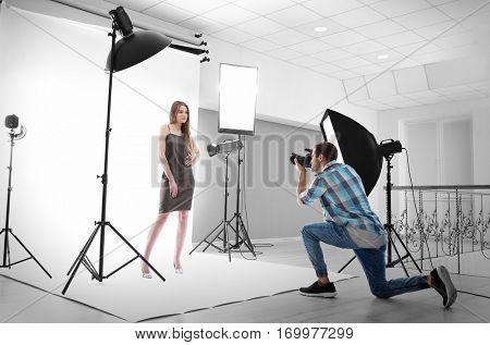 Photographer taking picture of  model in studio