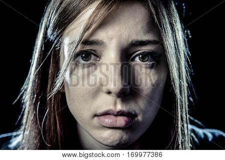 lonely young teenager girl or woman in stress and pain suffering depression looking sad and scared with fear face expression isolated on black background victim of abuse or in mental condition