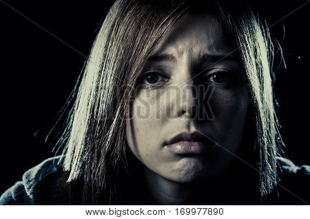 lonely young teenager girl or woman in stress and pain suffering depression looking sad and scared with fear face expression isolated on black background victim of abuse or in mental condition
