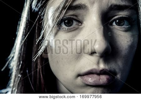 lonely young teenager girl or woman in stress and pain suffering depression looking sad and scared with fear face expression isolated on black background victim of abuse or in mental condition