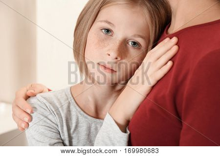 Woman becalming little sad girl, closeup