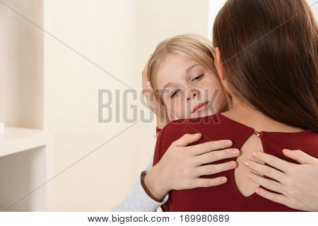 Woman becalming little sad girl, closeup