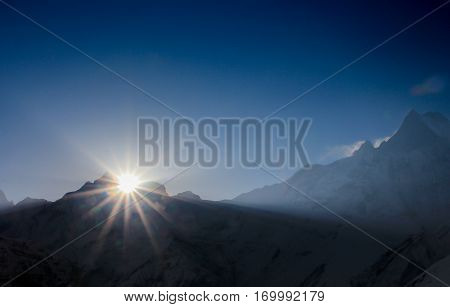 Before sunrise from Annapurna Base Camp (ABC) Trekking on the trail in the mountains. Sport girl with backpack travels in Himalayas. Nepal trek to ABC. Female traveler near Annapurna Base Camp. Snow a