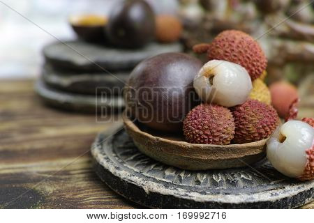 Tropical fruits - Lychees and Passion Fruit or Maracuya on wooden background
