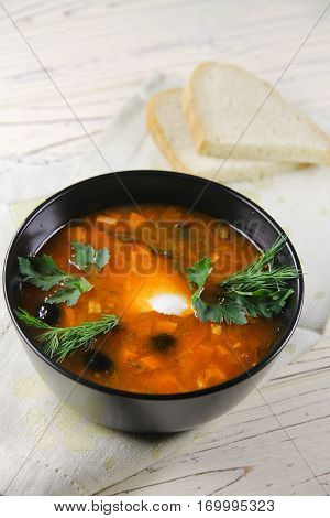 delicious saltwort soup in a black bowl and bread