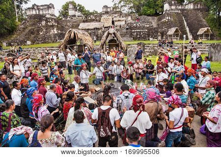 TIKAL, GUATEMALA - DEC 21, 2015: Unidentified Mayan people and tourists surround a fire on December 21, 2015  in Tikal, Guatemala. Traditional Mayan fire ceremony at the 2015 new year celebrations.