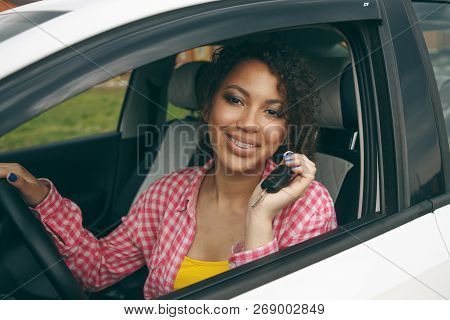 Young Asian Woman In Car.modern Young Girl Driver Drives A Car And Looks Away With A Smile With Brac