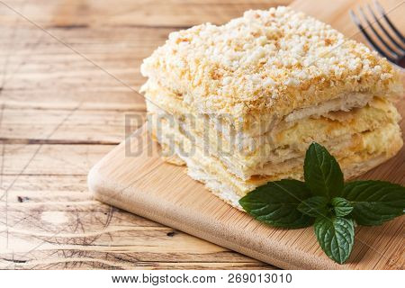 Layered Cake With Cream Napoleon Millefeuille Vanilla Slice With Mint On Wooden Background.