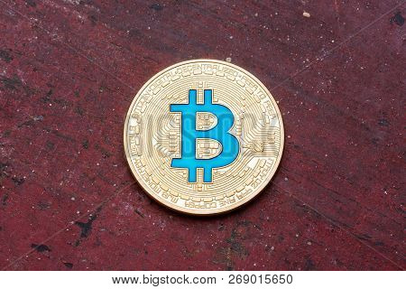 Golden Cryptocurrency Blue Bitcoin On Red Background, Cloose Up.