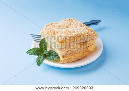 Layer Cake With Cream Napoleon Millefeuille Vanilla Slice With Mint On A Colored Blue Background.