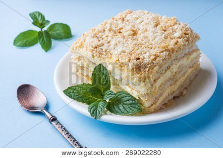 Layer Cake With Cream Napoleon Millefeuille Vanilla Slice With Mint On A Colored Blue Background.