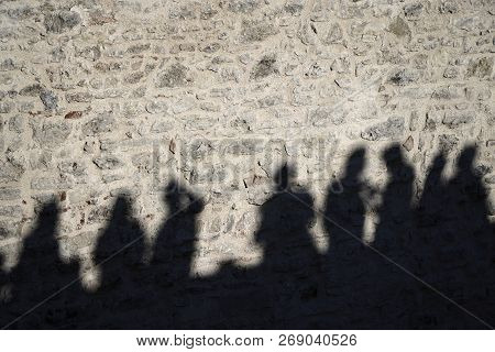 Shadows Of People On The Stone Wall