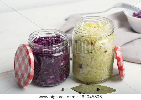 Purple And White Cabbage In Jars On A Wooden Table
