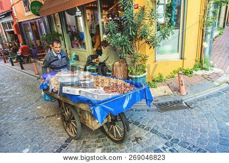 Istanbul, Turkey: Seller Of Nuts And Chestnuts At Traditional Street With Colorful Houses At Balat W