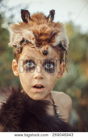 Surprised Funny Boy Portrait. Little Caveman With Open Mouth. Prehistoric Tribal Boy Outdoors On Nat