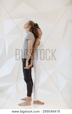 Happy Loving Couple Standing Back To Back With Closed On White Polygon Background. Young Couple In L