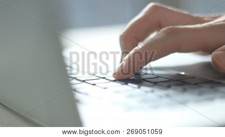 Close Up. Blurred Image Of Male Hand Typing On Laptop Keyboard