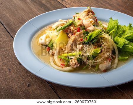 Close Up Thai Food Called Yum Woon Seng Or Sour & Spicy Vermicelli Salad With Squids. Food On Wood T