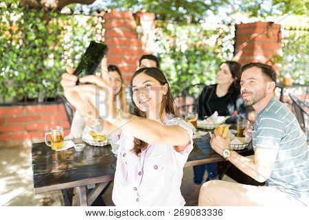 Smiling Young Woman Taking Selfportrait With Friends At Fast Food Restaurant