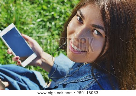 Young Talented Female Student Dressed In Casual Clothing Walking Around City And Listening To Favori