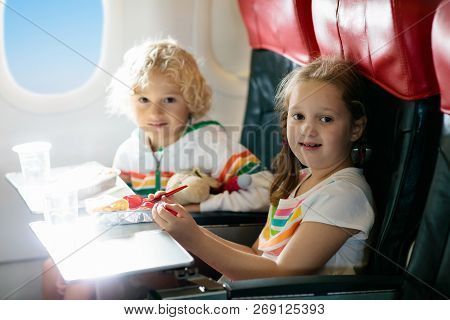 Child In Airplane. Kids Fly. Children Flight Meal