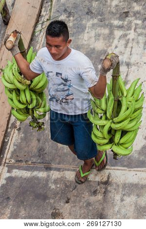 Napo, Peru - July 14, 2015: Cargo Boat Crew Transports Bunches Of Plantains To The Boat Deck. Cargo 