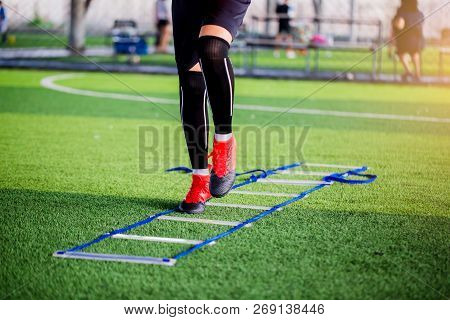 Young Boy Soccer Players Jogging And Jump Between Ladder Drills For Football Training.