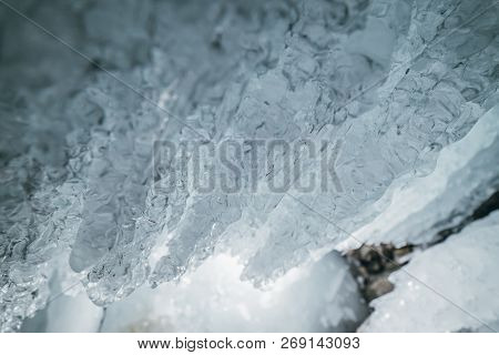 Winter Baikal. Olkhon Island. Ice Grotto. Thick Blue Ice And Icicles On The Coastal Rocks Of Olkhon 
