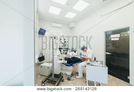 Doctor Used Microscope. Dentist Is Treating Patient In Modern Dental Office. Operation Is Carried Ou