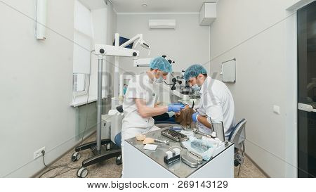 Doctor Used Microscope. Dentist Is Treating Patient In Modern Dental Office. Operation Is Carried Ou