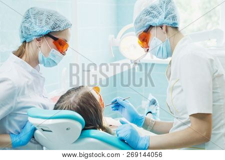 Girl Patient With Dentist And Assistant In A Dental Treatment