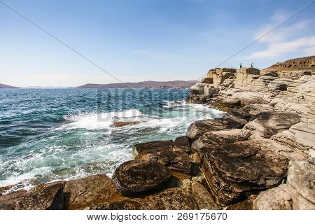 Small Wave Crashing Against The Rocks With Splashes In Selective Focus Daylight