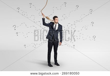Hopeless young businessman trying to suicide with question signs concept