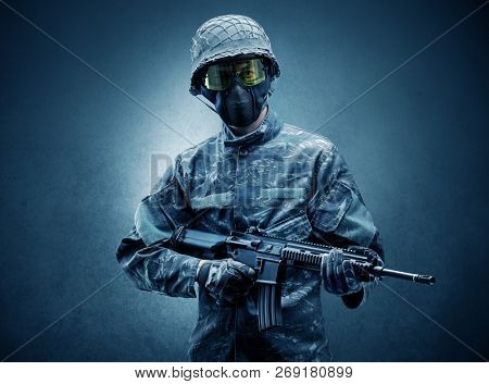 Soldier agent in a dark room with arms on his hand and gas mask