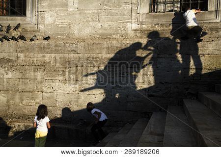 Istanbul, Turkey - September 8, 2010: Two Little Girl Were Playing With Pigeons. A Boy Was Climbing 