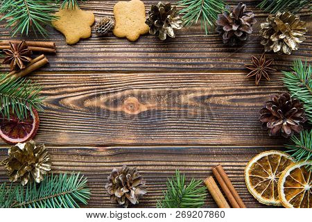 Christmas Frame. Fir Branches, Golden Cones, Gingerbreadcookies On Brown Wooden Table Background. Sp