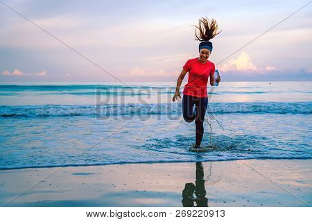Girl Running Workout Jogging On The Beach In The Morning. Relax And Happy With Running On The Sea. I