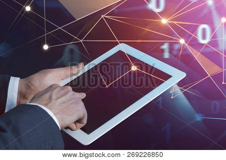 Hands Of Businessman Using Tablet With Glowing Netowrk Hologram And Lines Of Code Over Dark Backgrou