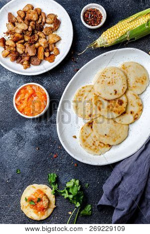 Colombian Food. Maize Arepas And Fried Pork Chicharron Ans Colombian Tomato Sauce. Top View. Black B
