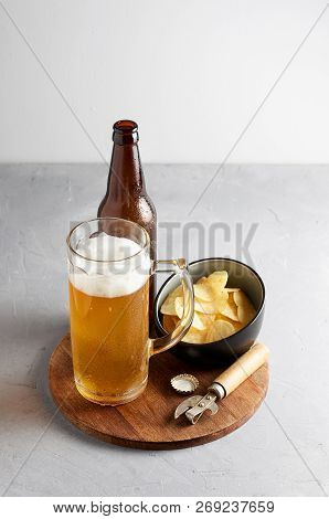 Lager Beer In Glass And Bottle With Potato Chips On Gray Concrete Background