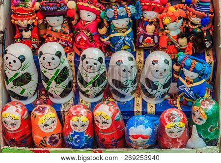 Traditional Chinese Dolls And Russian Matryoshka Along With Stylized Panda Bear Nesting Toys On Disp
