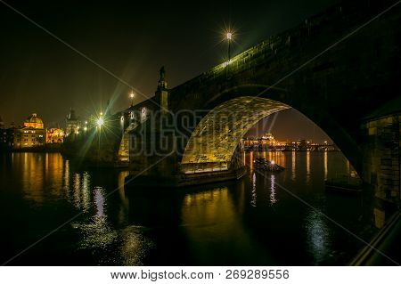 Night View Of Illuminated Stone Charles Bridge With Statues, Street Lamps, Church Of St Francis Assi