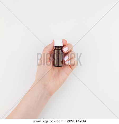 Woman Hand With Manicure Polish Holding Small Glass Bottle Isolated White Background With Copy Space